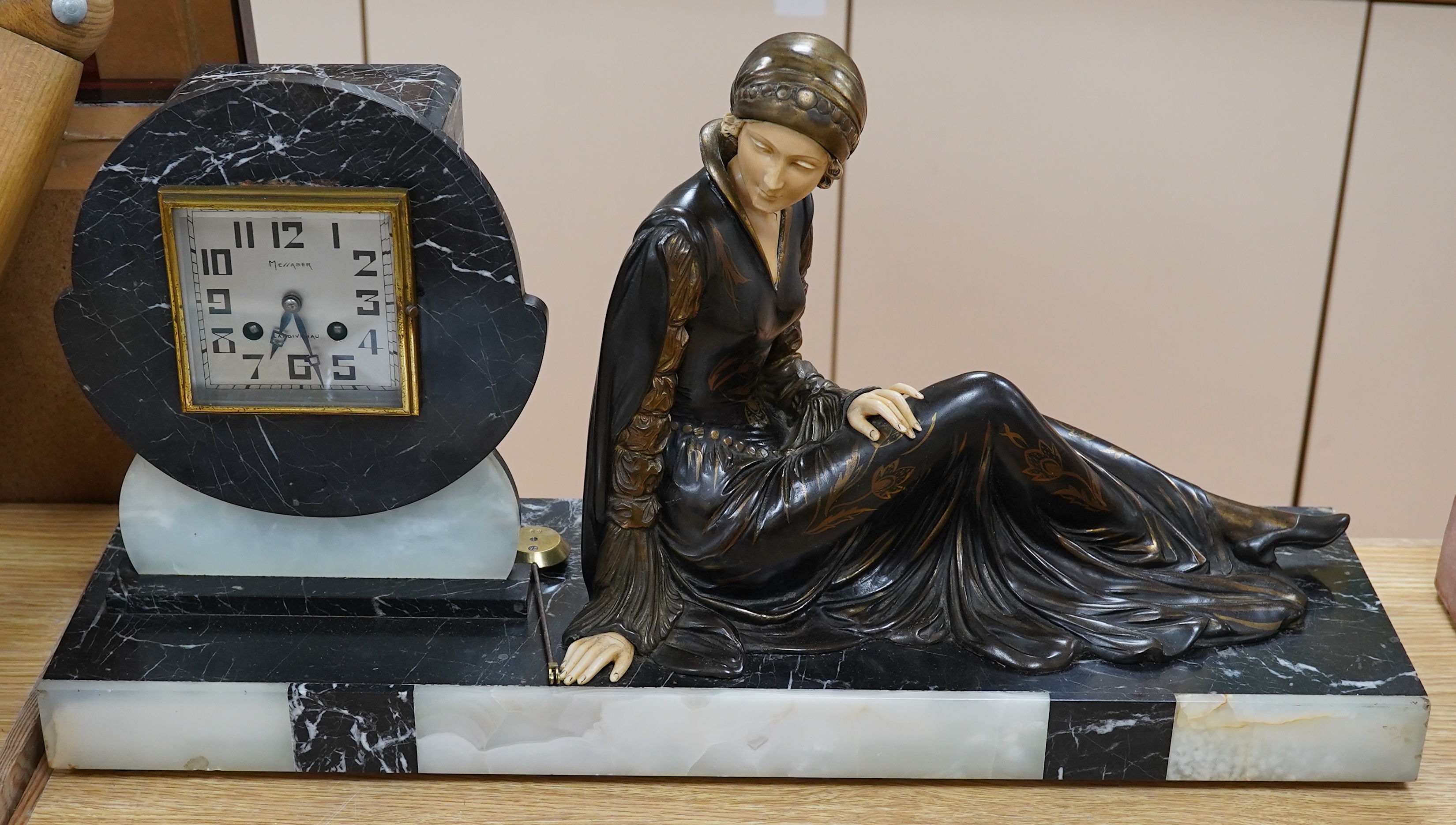 A French Art Deco black and white marble clock, with an ornately painted Spelter figure of a seated lady, width 62cm. Condition - good, unknown if clock in working order